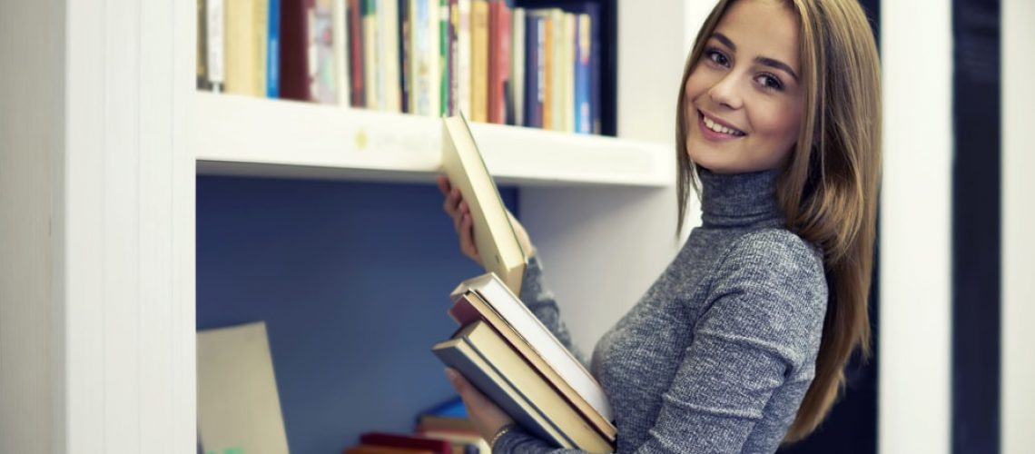 Student Holding Literature For Online Course